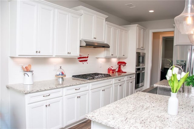 2159 Holland Creek Ln, Buford, GA 30519 - kitchen featuring under cabinet range hood, stainless steel appliances, white cabinetry, decorative backsplash, and light stone counters
