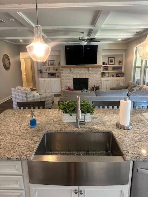 2159 Holland Creek Ln, Buford, GA 30519 - kitchen featuring coffered ceiling, open floor plan, a sink, ceiling fan, and light stone countertops