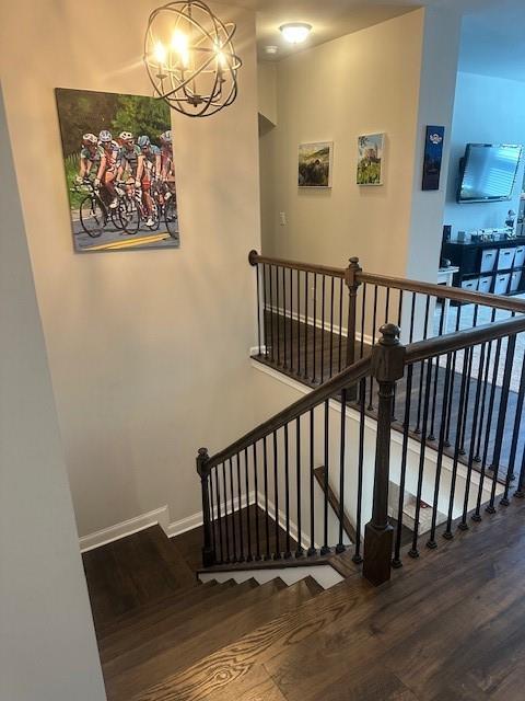 2159 Holland Creek Ln, Buford, GA 30519 - staircase featuring wood finished floors, a chandelier, and baseboards