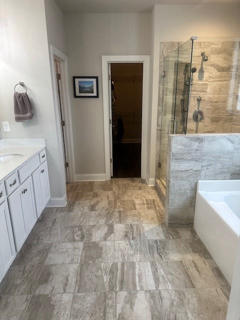 2159 Holland Creek Ln, Buford, GA 30519 - full bathroom with a stall shower, a garden tub, a walk in closet, and vanity