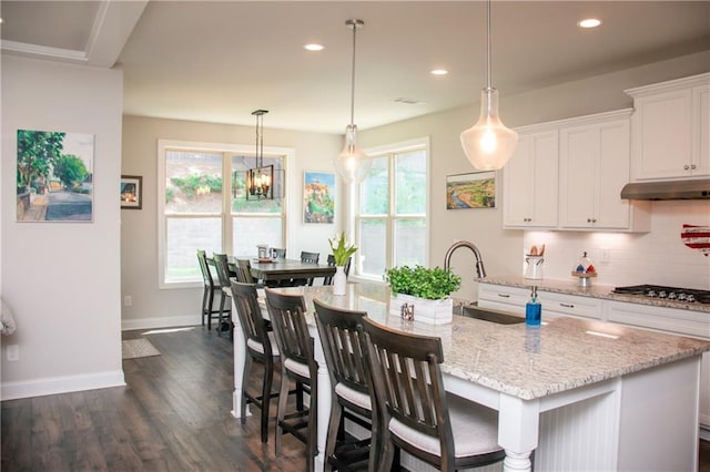 2159 Holland Creek Ln, Buford, GA 30519 - kitchen with gas stovetop, under cabinet range hood, tasteful backsplash, healthy amount of natural light, and recessed lighting
