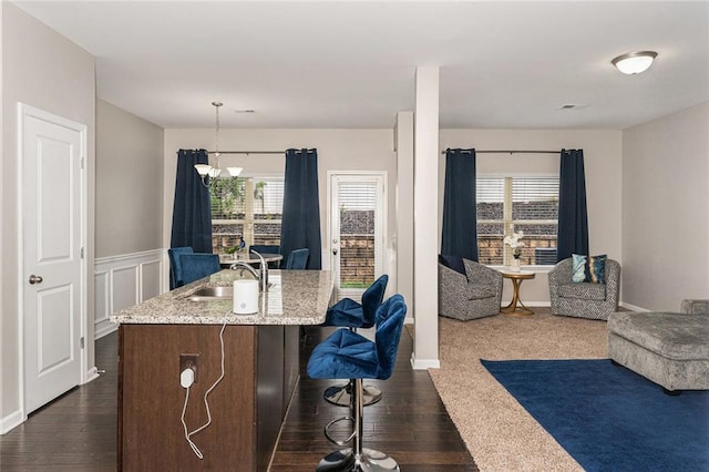 368 Rankin Cir, Mcdonough, GA 30253 - kitchen featuring open floor plan, plenty of natural light, dark wood finished floors, light stone countertops, and wainscoting