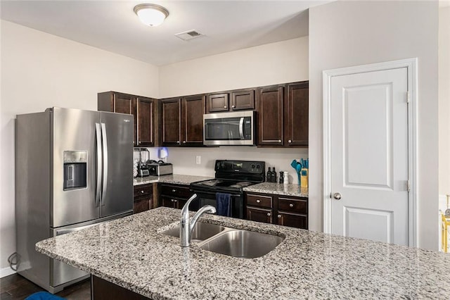368 Rankin Cir, Mcdonough, GA 30253 - kitchen with appliances with stainless steel finishes, dark brown cabinets, light stone counters, dark wood-style floors, and a kitchen breakfast bar