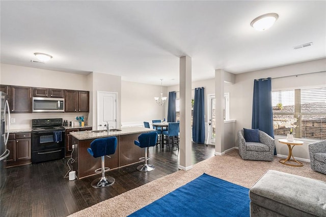 368 Rankin Cir, Mcdonough, GA 30253 - kitchen with appliances with stainless steel finishes, a breakfast bar, open floor plan, dark brown cabinets, and a kitchen island with sink