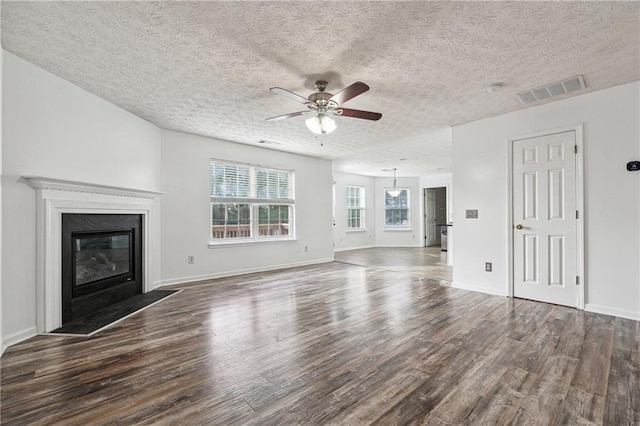 unfurnished living room with ceiling fan, a textured ceiling, and dark hardwood / wood-style flooring