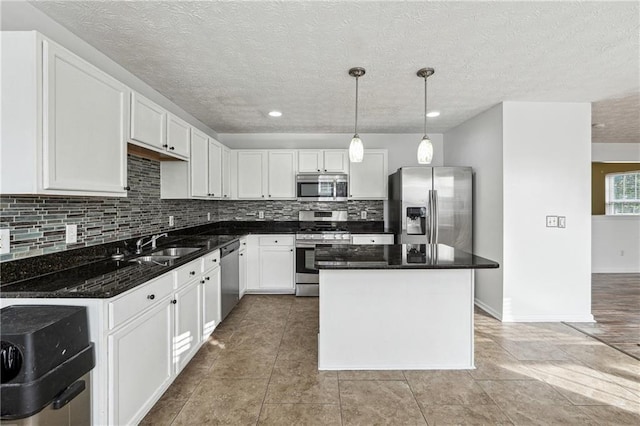 kitchen with pendant lighting, white cabinetry, a center island, and stainless steel appliances