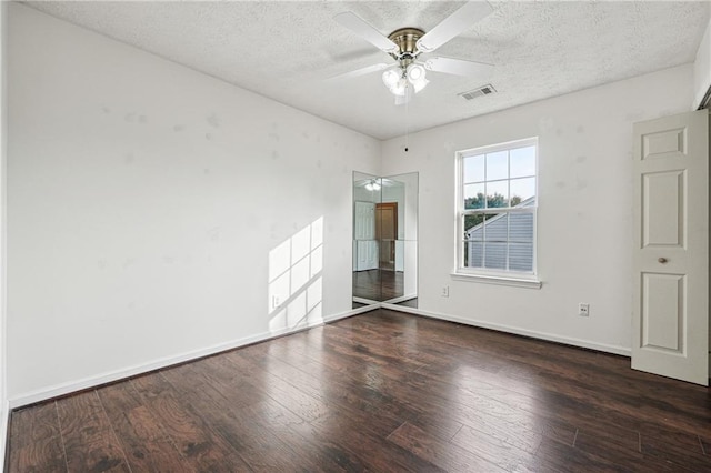 empty room with ceiling fan and dark hardwood / wood-style flooring