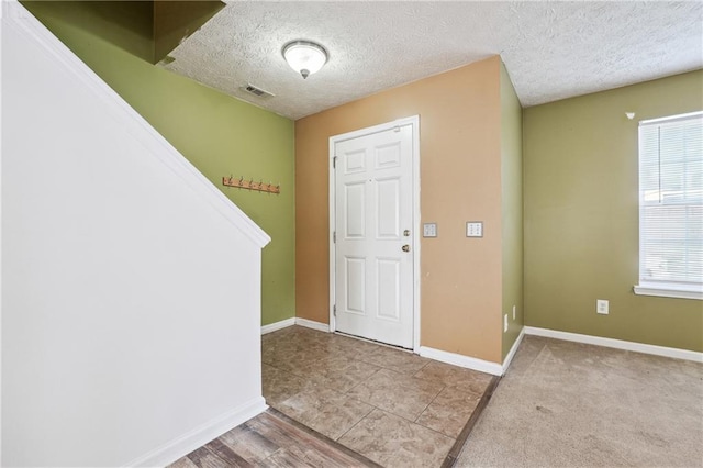 foyer with a textured ceiling and light hardwood / wood-style floors