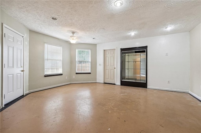 spare room featuring concrete flooring, a textured ceiling, and ceiling fan