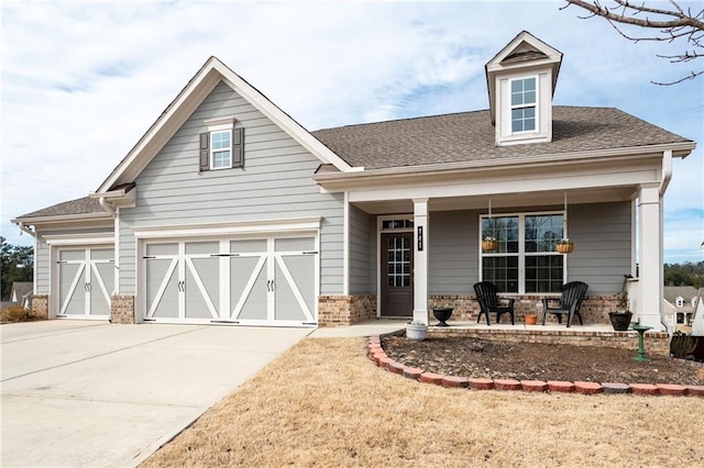 view of front of home featuring a garage, covered porch, and a front lawn