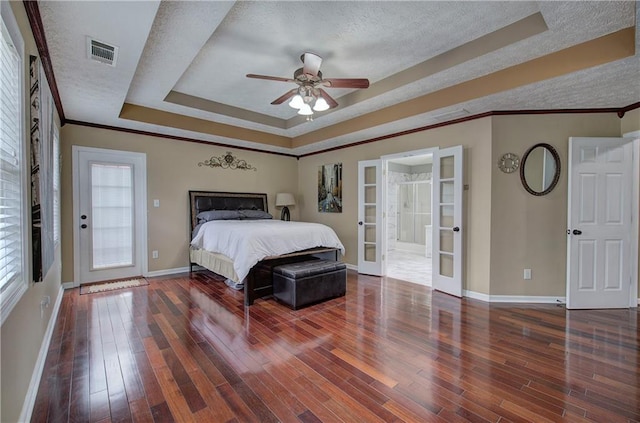 bedroom featuring a raised ceiling, a textured ceiling, and french doors