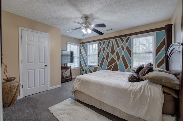 bedroom with ceiling fan, carpet flooring, and a textured ceiling