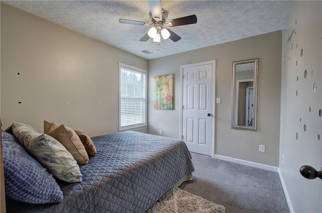 carpeted bedroom with ceiling fan and a textured ceiling