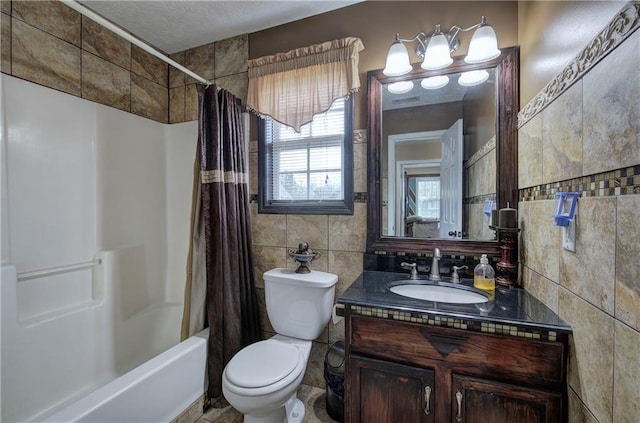 full bathroom featuring tile walls, vanity, toilet, and shower / bath combo