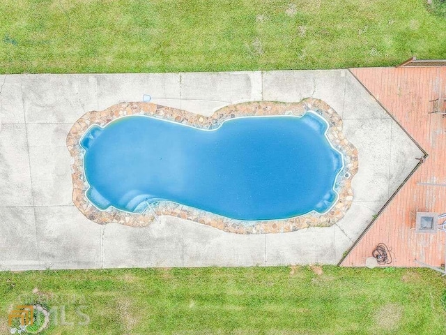 view of pool with a lawn