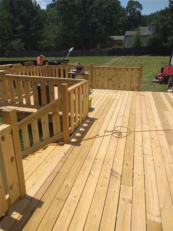 wooden deck featuring a lawn