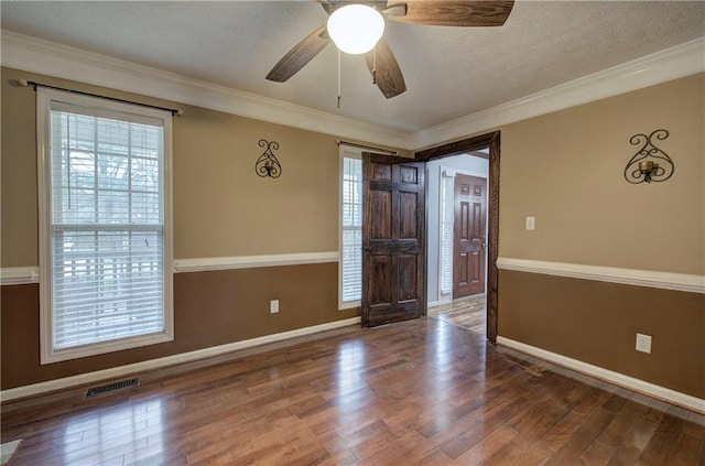 spare room with ornamental molding, wood-type flooring, and plenty of natural light