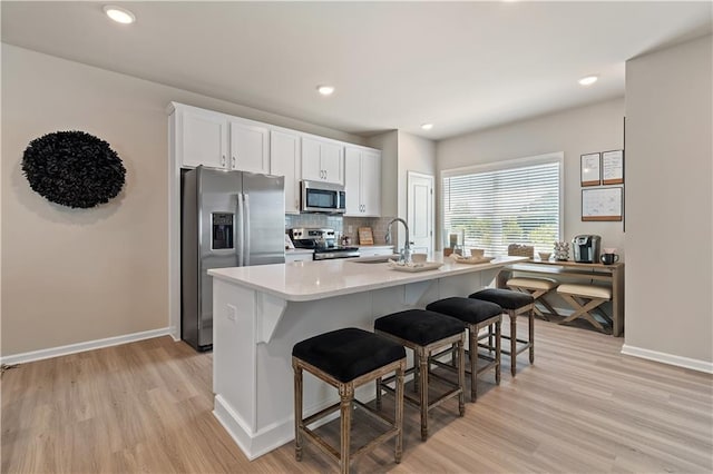 27 Cobalt Ln Unit 77, Newnan, GA 30265 - kitchen with stainless steel appliances, a sink, light wood-type flooring, a kitchen bar, and baseboards