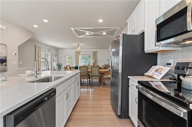 27 Cobalt Ln Unit 77, Newnan, GA 30265 - kitchen with appliances with stainless steel finishes, a sink, white cabinetry, light wood finished floors, and ceiling fan