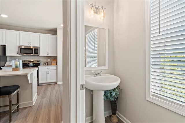 27 Cobalt Ln Unit 77, Newnan, GA 30265 - bathroom with wood finished floors, decorative backsplash, baseboards, and a sink