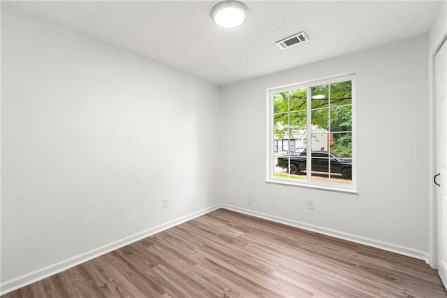 unfurnished room with hardwood / wood-style flooring