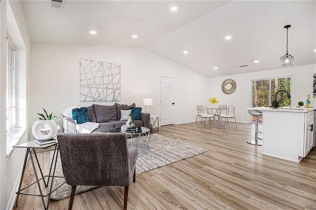 living room featuring lofted ceiling and light wood-type flooring