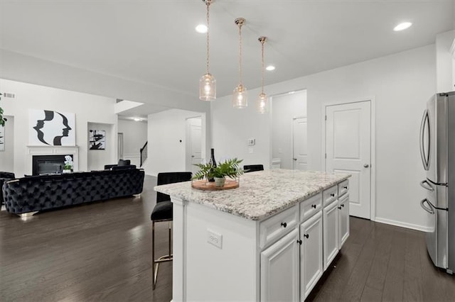 kitchen with white cabinets, freestanding refrigerator, dark wood finished floors, and open floor plan