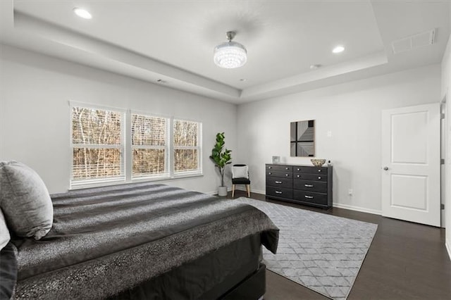 bedroom featuring visible vents, baseboards, dark wood-style floors, recessed lighting, and a tray ceiling