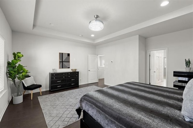bedroom with recessed lighting, baseboards, a tray ceiling, and dark wood-style floors