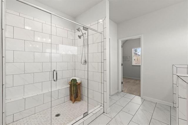 full bath with baseboards, marble finish floor, and a stall shower