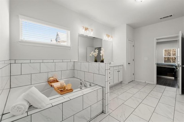 bathroom with visible vents, a garden tub, marble finish floor, vanity, and baseboards