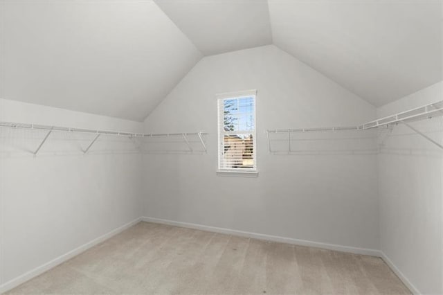 spacious closet with light carpet and lofted ceiling