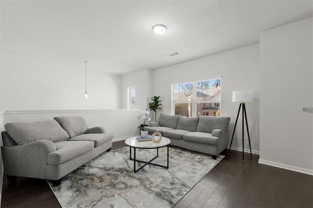 living area featuring baseboards and dark wood-type flooring