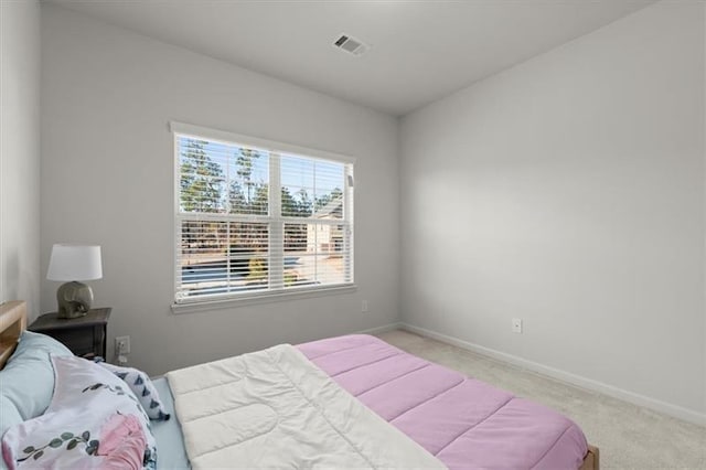carpeted bedroom featuring baseboards and visible vents