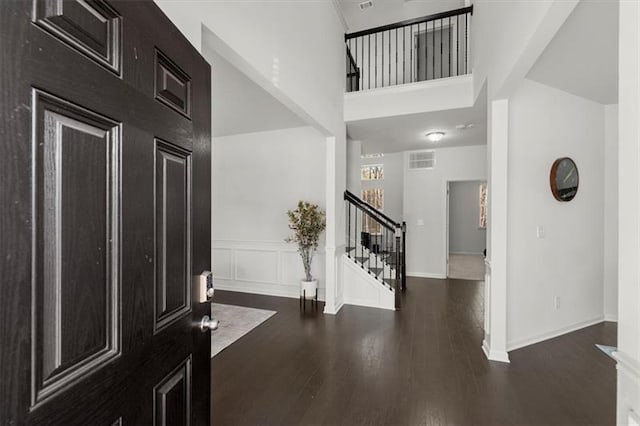 entrance foyer featuring stairway, baseboards, wood finished floors, and visible vents
