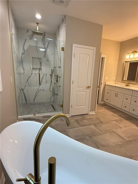 bathroom with double vanity, a freestanding tub, and baseboards
