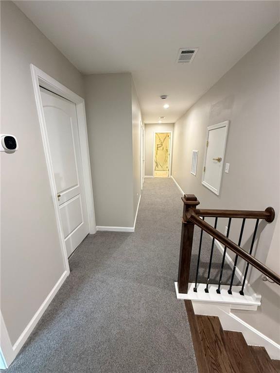 unfurnished room with dark carpet and baseboards