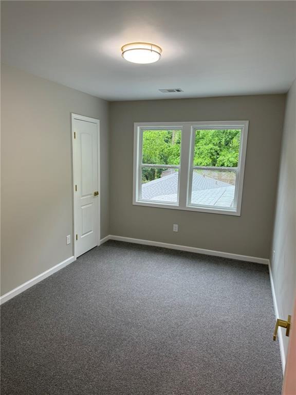 back of property with a yard, a carport, a wooden deck, and a patio area