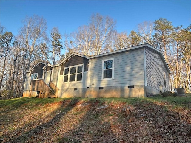 view of side of property with crawl space and central AC