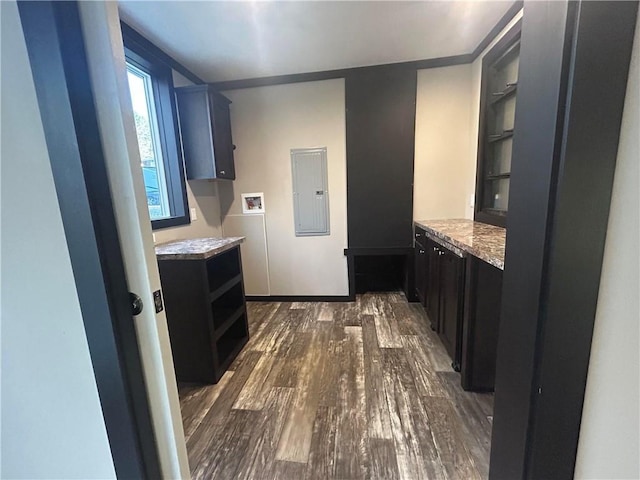 bathroom featuring electric panel, wood finished floors, baseboards, and built in shelves