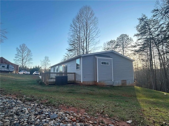 view of side of property with a yard and a wooden deck