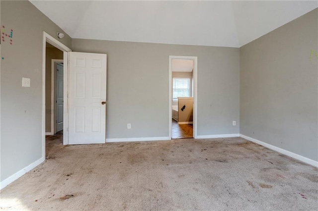 unfurnished bedroom featuring light carpet and vaulted ceiling