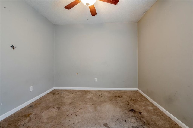 carpeted spare room featuring ceiling fan and a textured ceiling