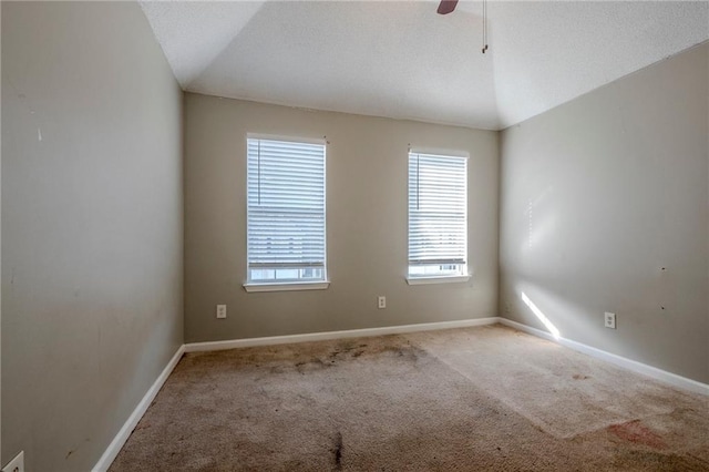 carpeted empty room with ceiling fan and lofted ceiling