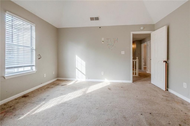 carpeted empty room featuring lofted ceiling