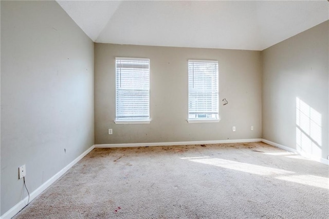 unfurnished room with light carpet and lofted ceiling