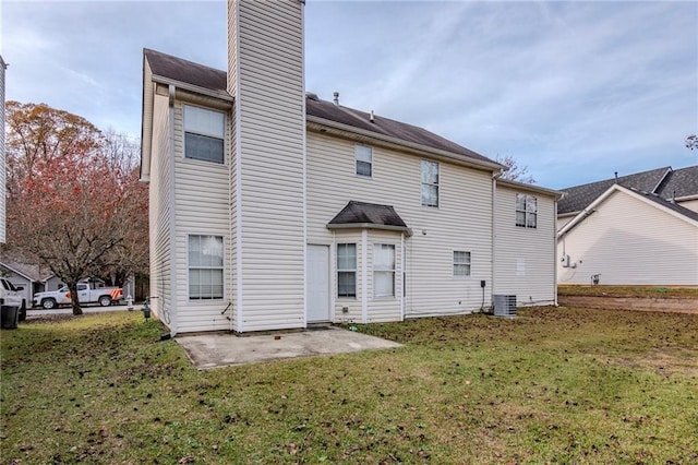 rear view of property with a lawn, a patio area, and central air condition unit