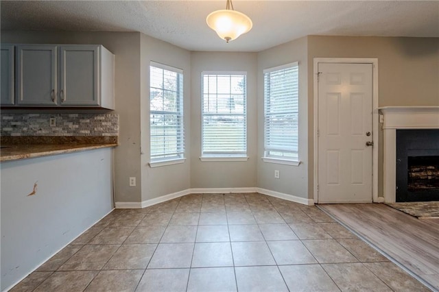 interior space with light hardwood / wood-style flooring, a healthy amount of sunlight, and a textured ceiling