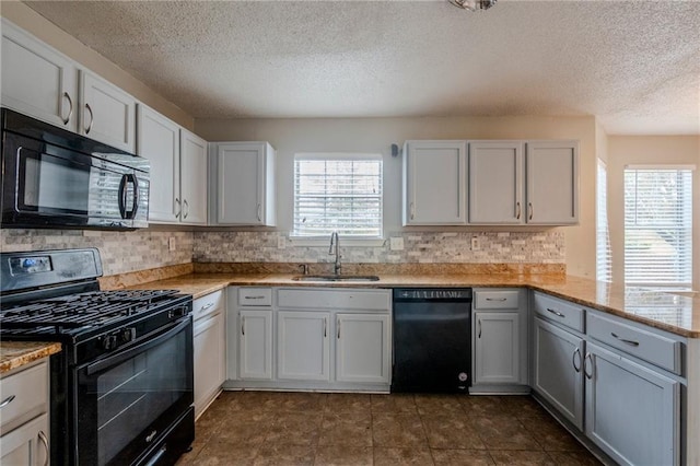 kitchen featuring white cabinetry, a healthy amount of sunlight, sink, and black appliances