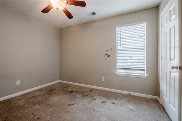 carpeted spare room with ceiling fan and plenty of natural light